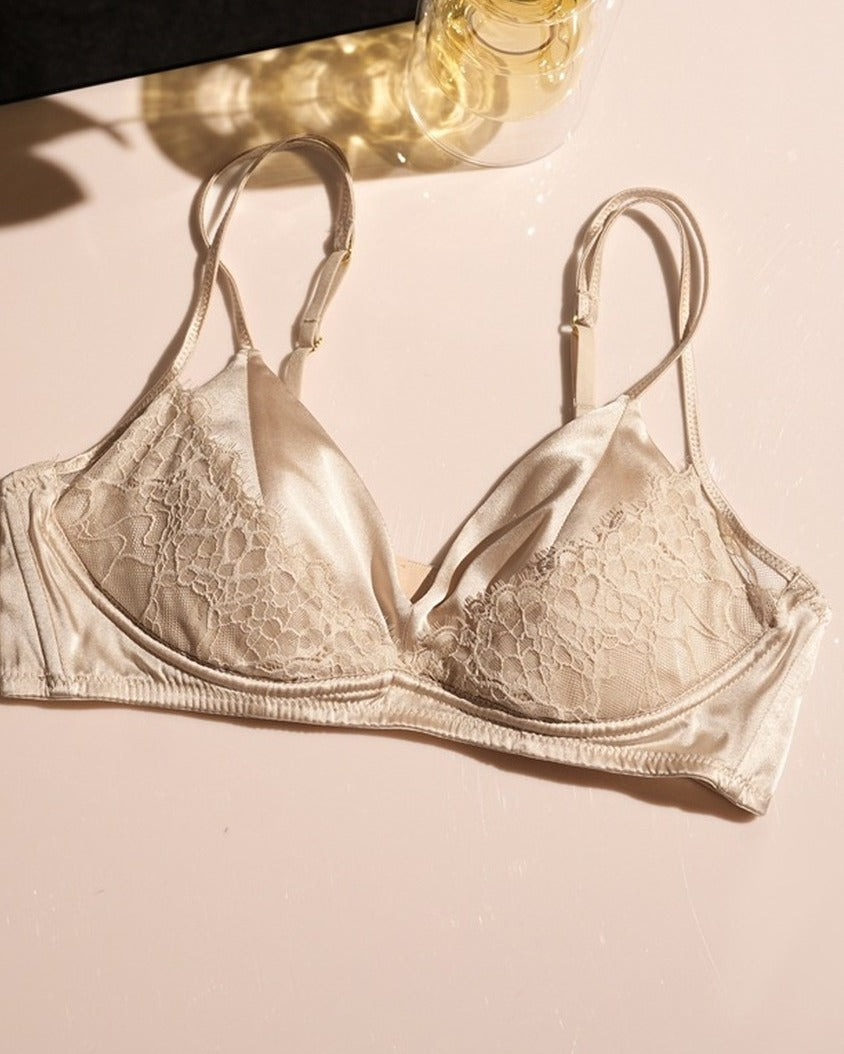 Darette Bare Minimum Silk Set in Champagne - flat lay of the silk and lace bra against a floral backdrop