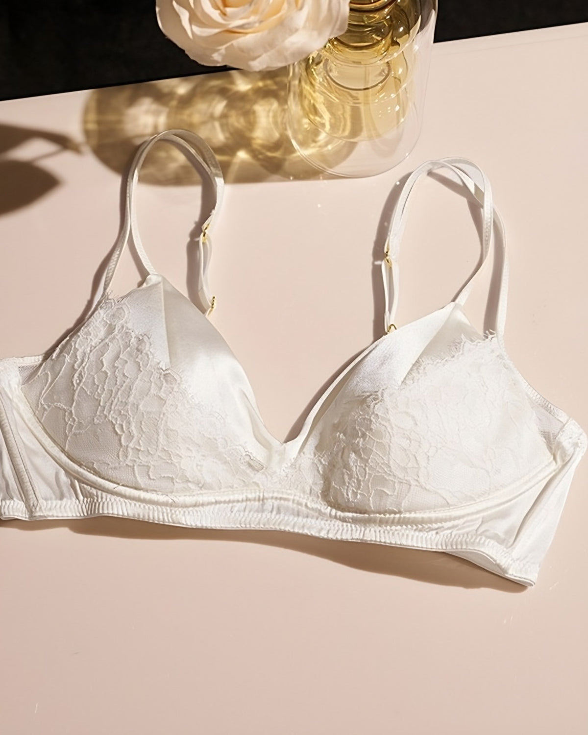 Darette Bare Minimum Silk Set in Ivory - flat lay of the silk and lace bra against a floral backdrop