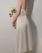 Back view of the Darette Cover Story Set in Ivory - lace-up open back on the satin slip gown, holding a rose
