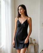 Darette Curtain Call Silk Slip in Noir - V-neck satin cami slip dress in a softly lit interior