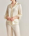 Darette Feather Weight Silk Set in Ivory - satin pajama set with feather cuffs, hands clasped in front