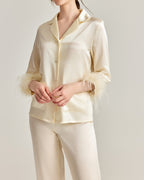 Darette Feather Weight Silk Set in Ivory - satin pajama set with feather cuffs, hands clasped in front