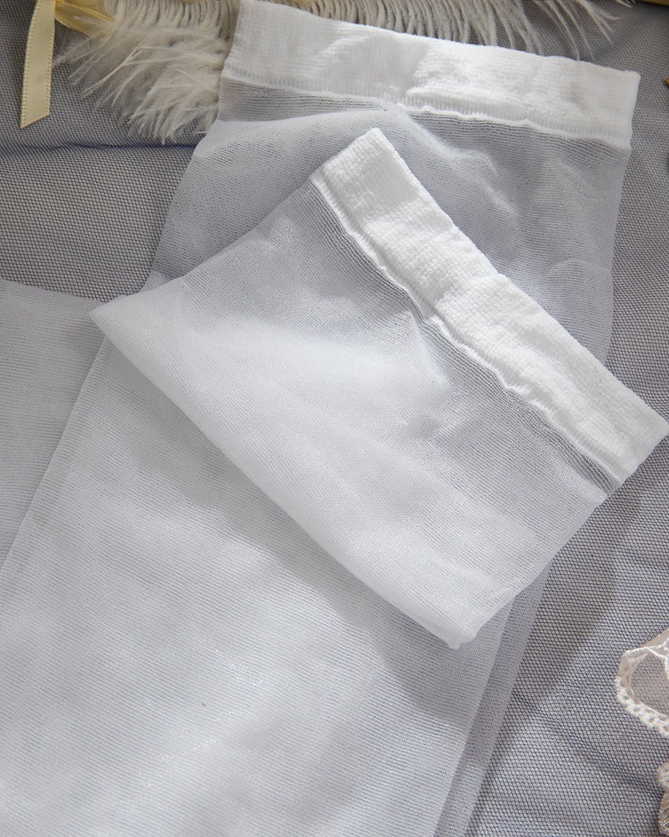 Flat lay of the Darette Fine Print Garter Set in Ivory - folded lace and satin fabric pieces