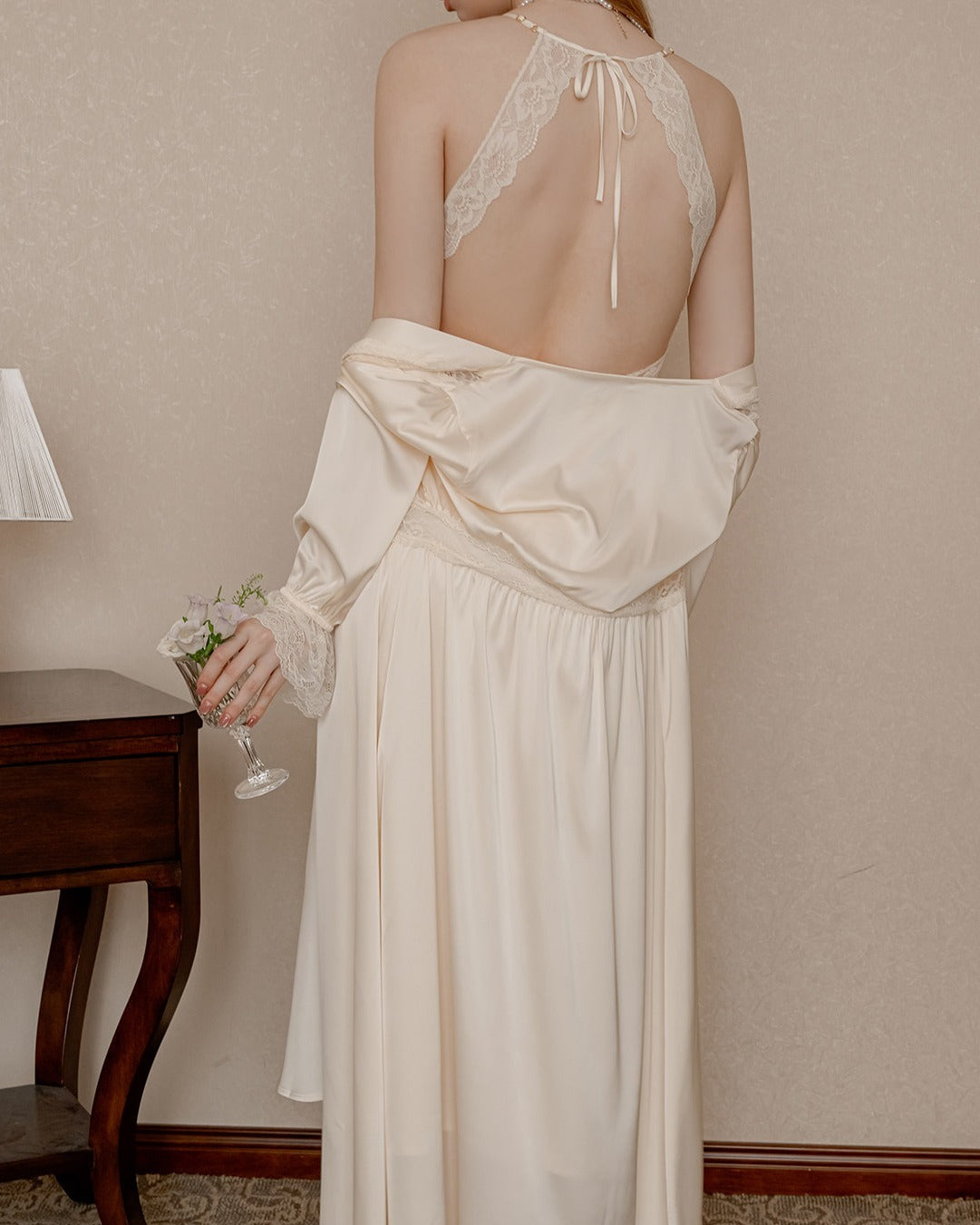 Back view of the Darette First Light slip in Champagne - open halter back with lace trim, robe slipping off the arms