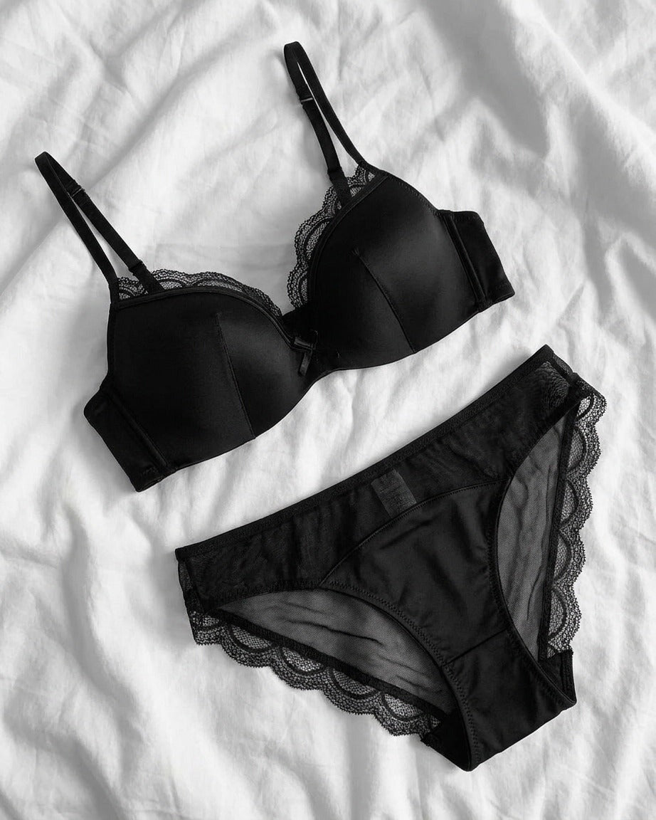Darette Golden Hour Satin-Lace Set in Noir - lace-trimmed bra and panty laid flat on bed linen