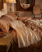 Darette Lash Line Lace Slip in Champagne - flat lay on the bed beside a glass of champagne and jewelry