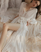 Darette Late Start Robe in Ivory - satin robe with lace trim, reclining on the bed