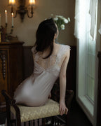 Darette Long Story Slip in Mauve - seated back view by candlelight, showing the open lace-trimmed back