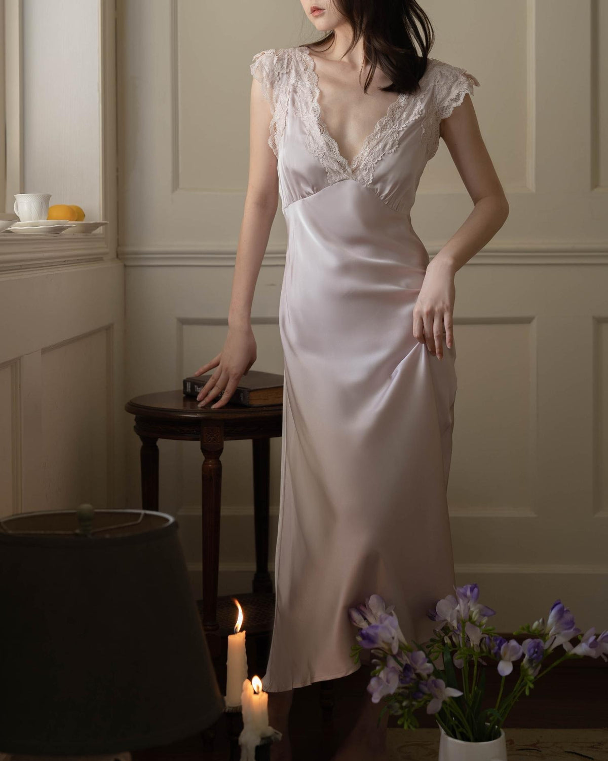 Darette Long Story Slip in Mauve - full-length side view in a candlelit room with flowers