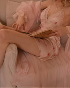 Darette Loose Ends Slip in Blush - front view reclining on a chair with a book, wearing a matching robe