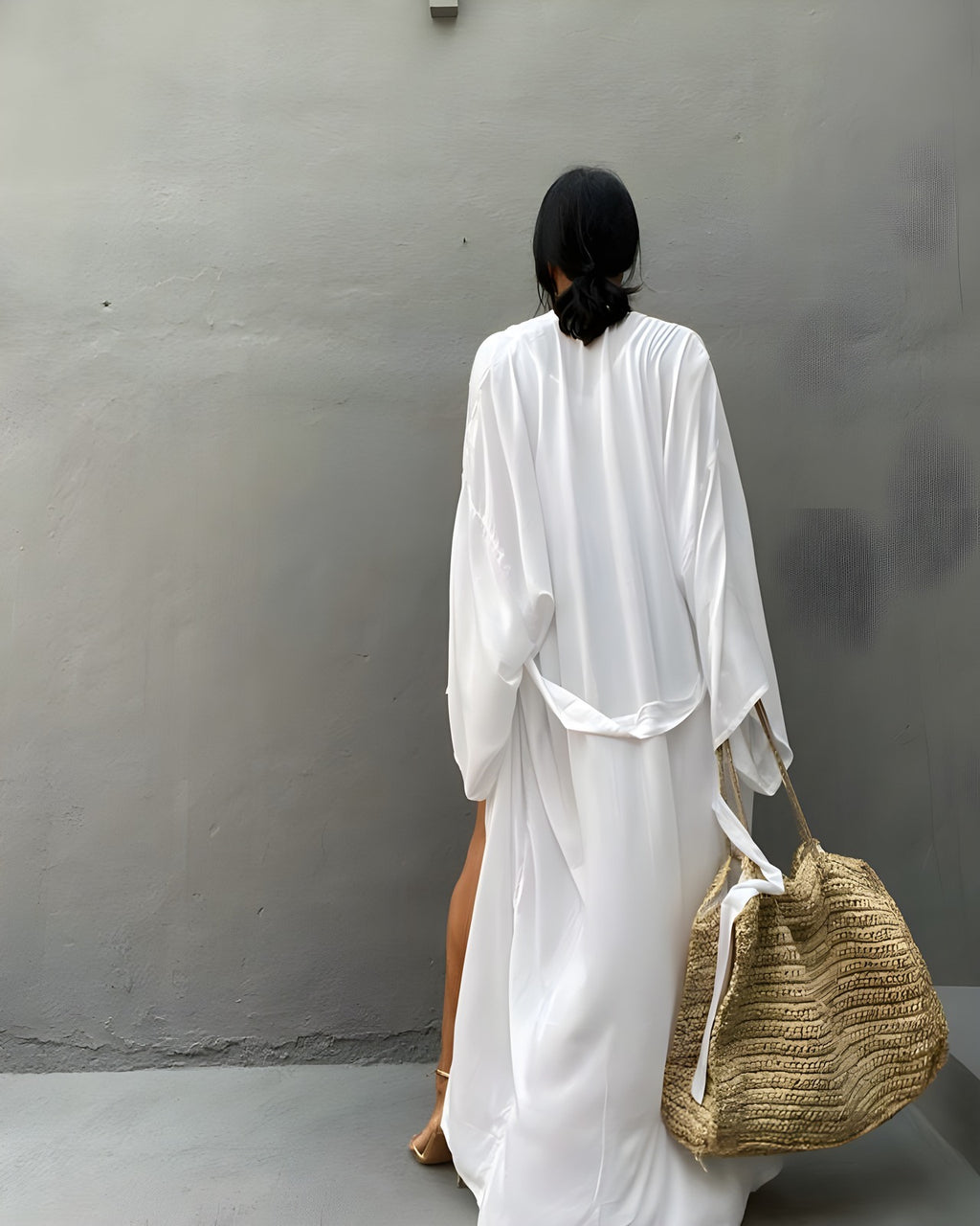 Back view of the Darette Out of Office Cover-Up in Ivory - flowing robe worn open, carrying a woven tote