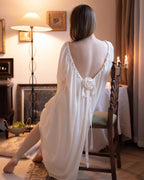 Darette Rose to the Occasion Gown seated on a chair, showing the low back and leg slit